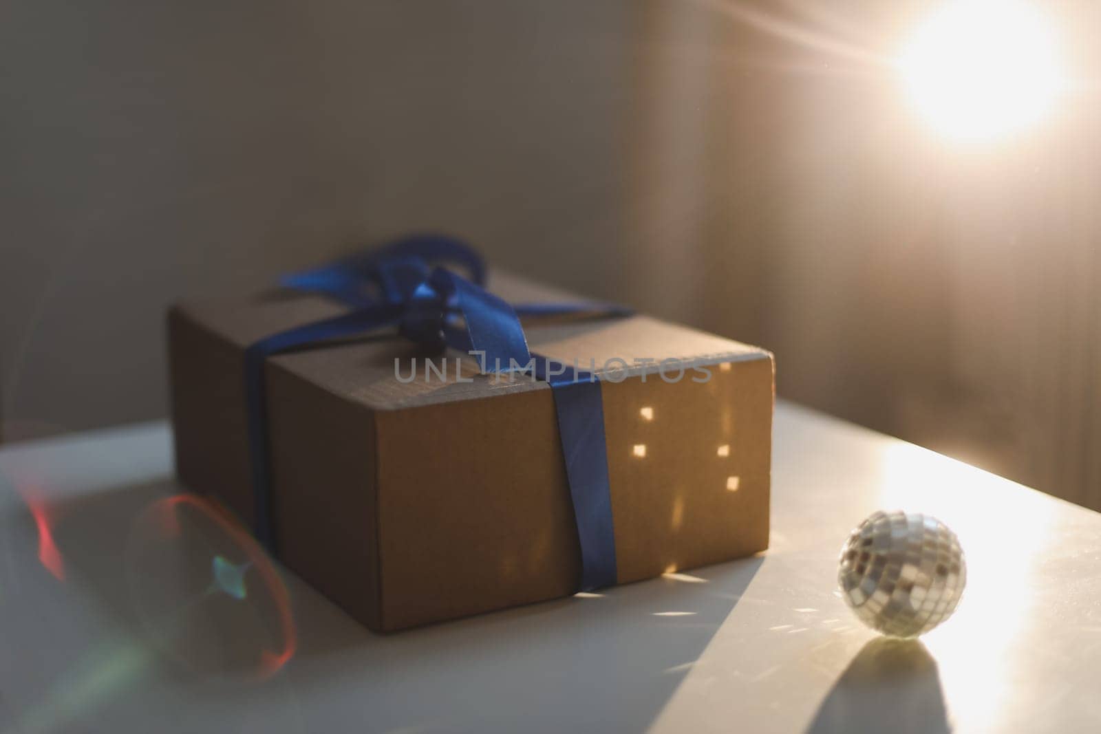 Gift box wrapped in craft paper with blue ribbon. High quality photo