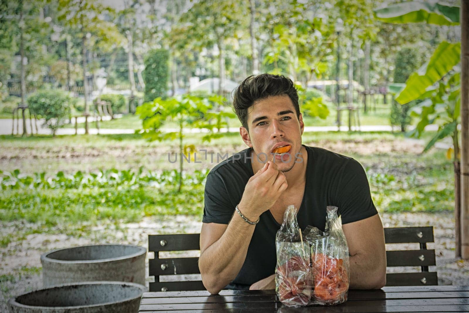 A man sitting at a table eating food, having dried fruits