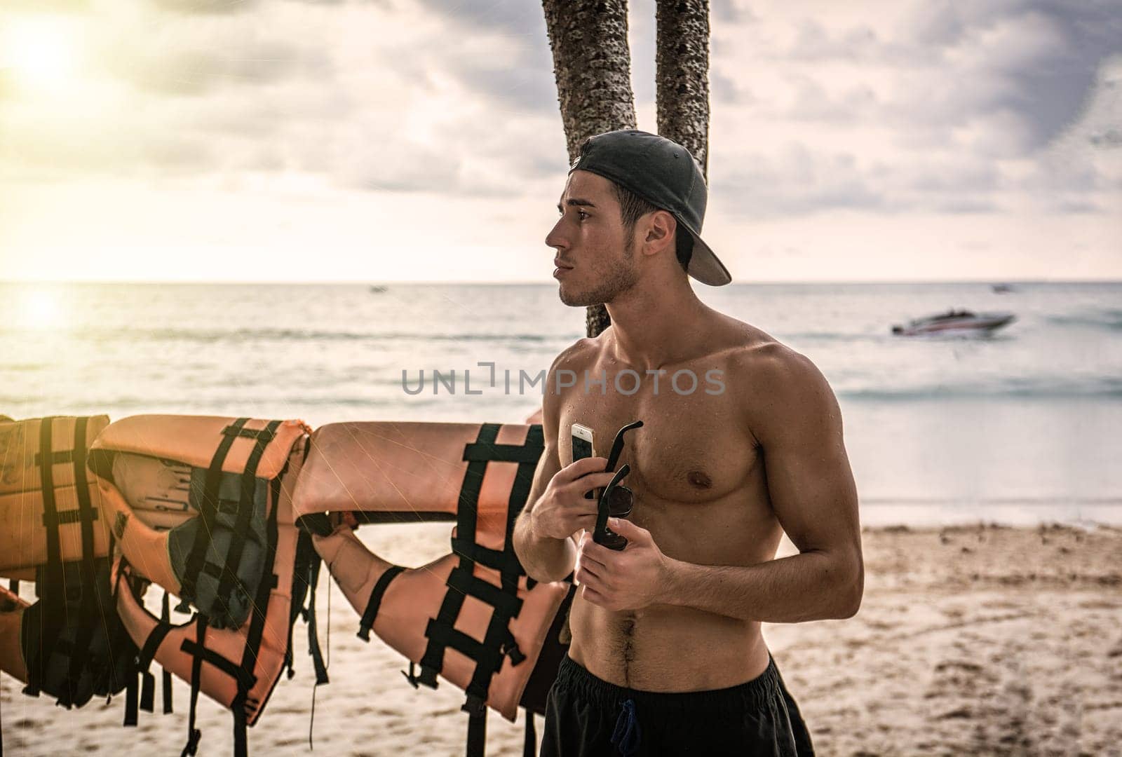 A man standing on a beach holding a surfboard