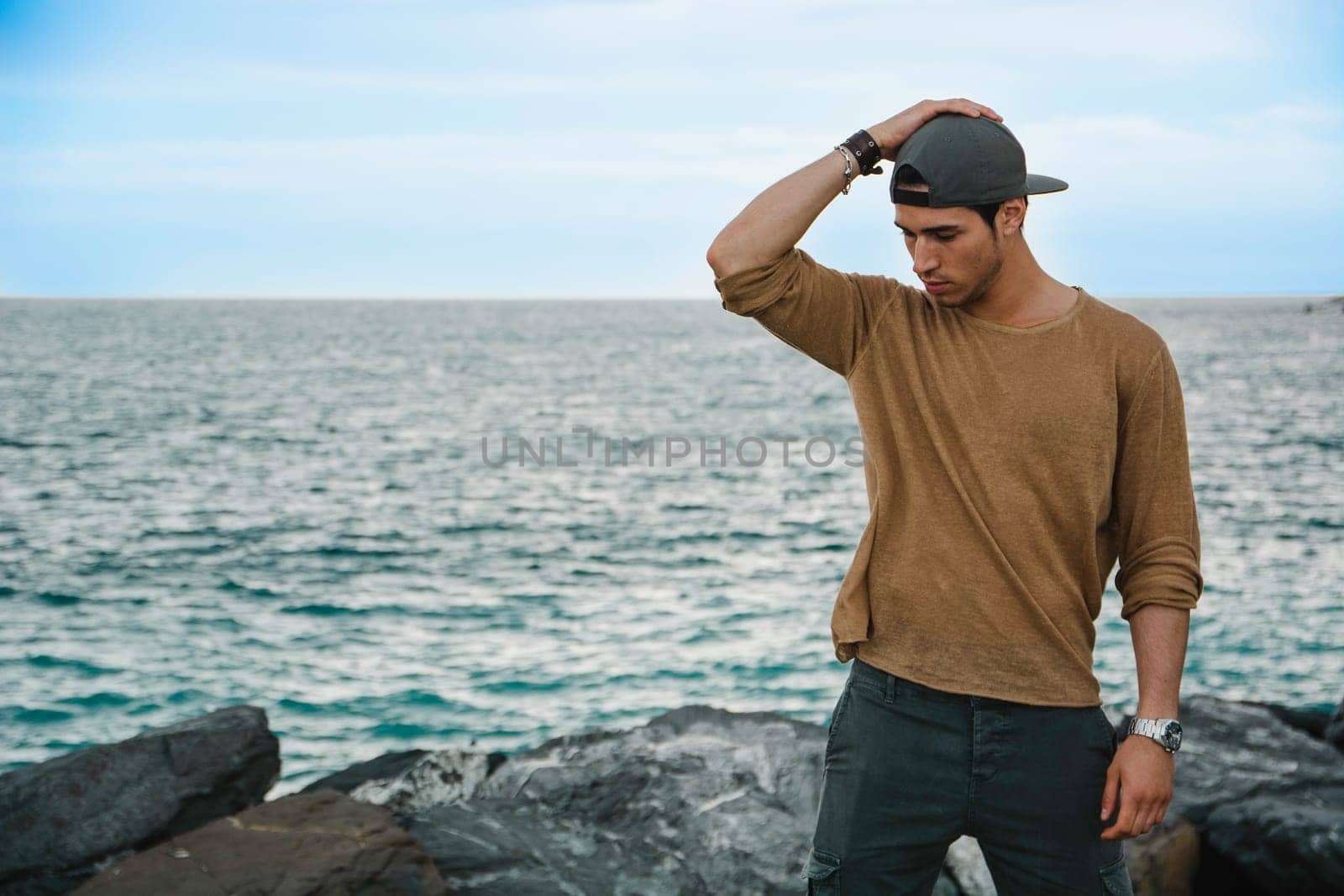 Man Enjoying the View of a Rocky Beach by the Ocean by artofphoto