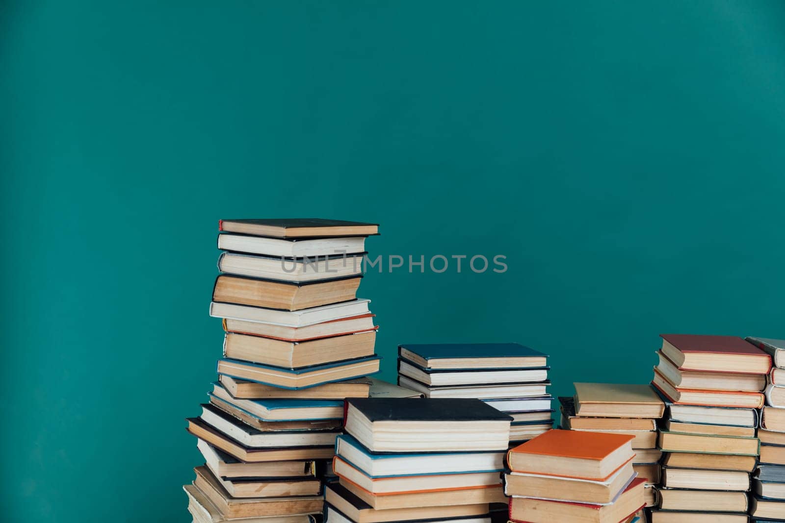 Stacks of books in university library on green background by Simakov