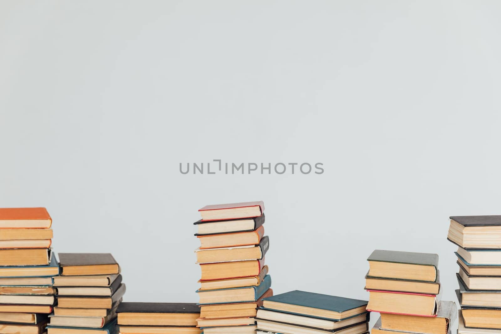 Stacks of educational books in university library on white background by Simakov