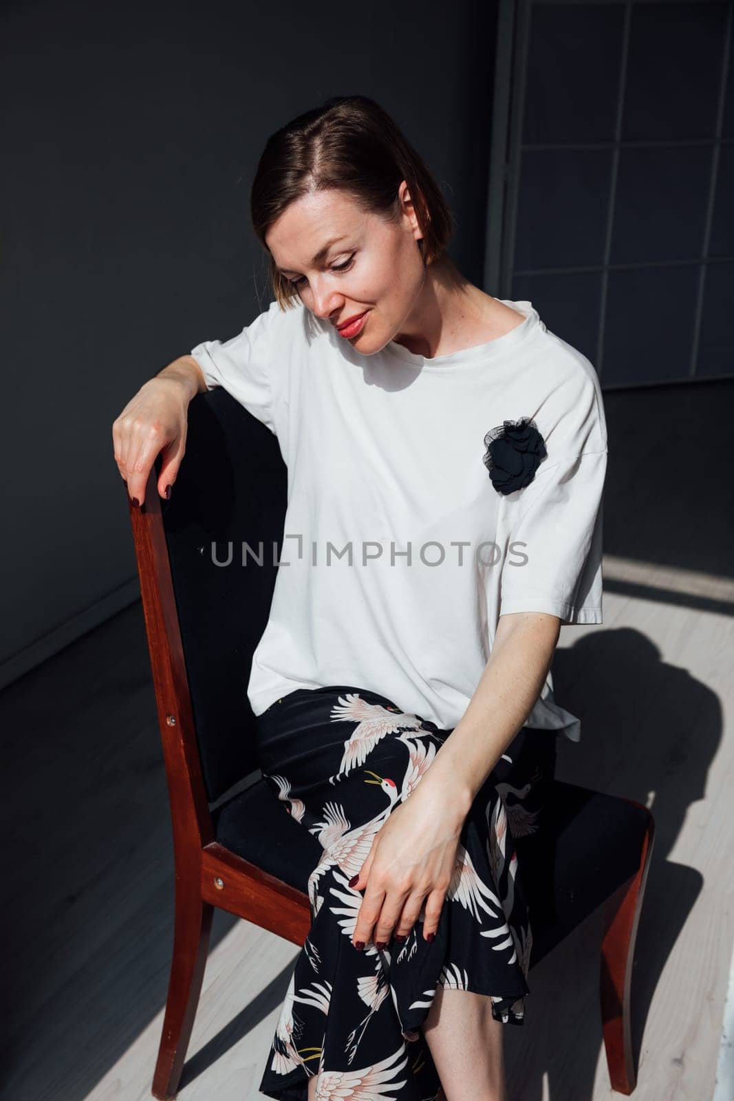 Portrait of a beautiful woman in a summer suit sitting on a chair