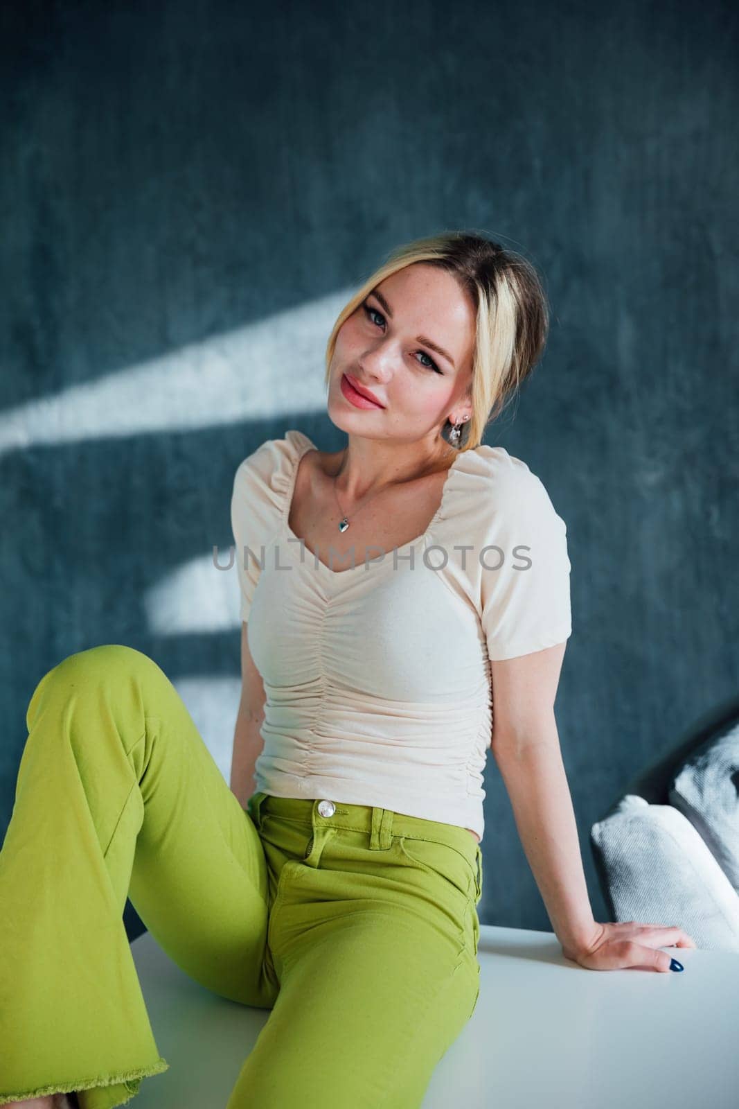 fashionable woman sitting on white table