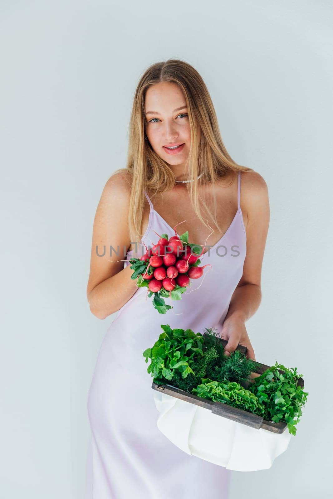 Fashionable woman holding a clutch with greens of vegetables in her hands