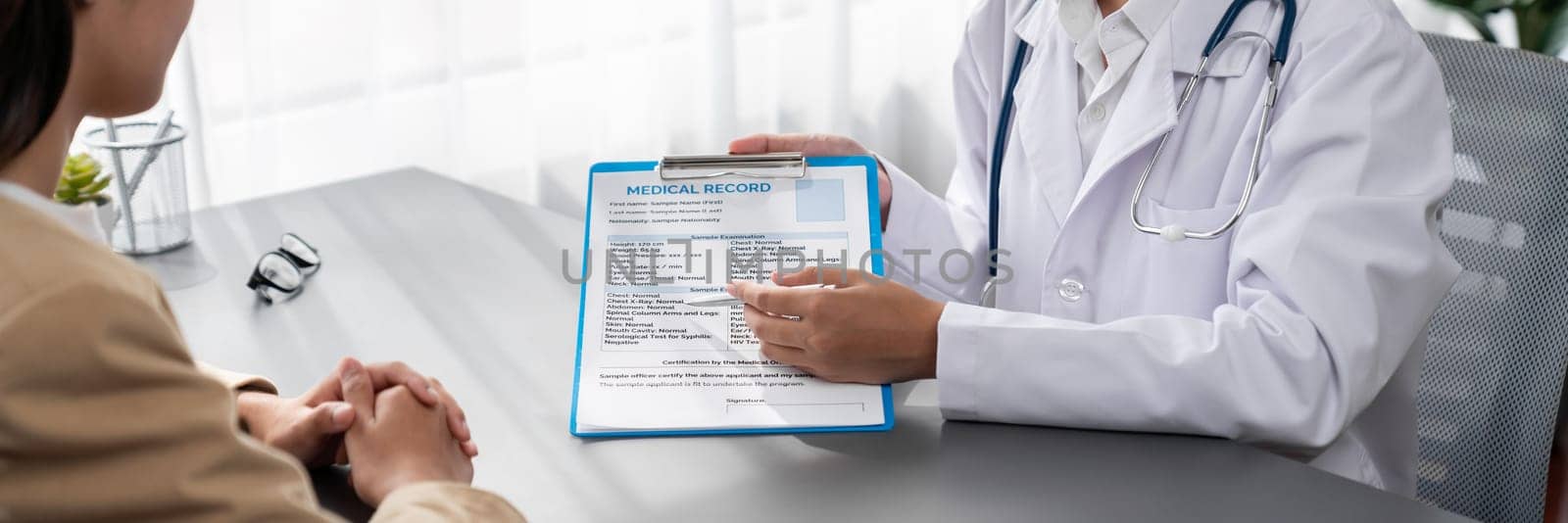 Doctor show medical diagnosis report and providing compassionate healthcare consultation to young patient in doctor clinic office. Doctor appointment and medical consult concept. Neoteric