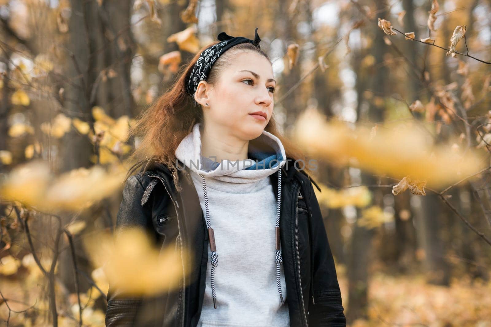 Outdoor atmospheric lifestyle portrait of young beautiful young woman copy space. Warm autumn fall season. Millennial generation and youth.