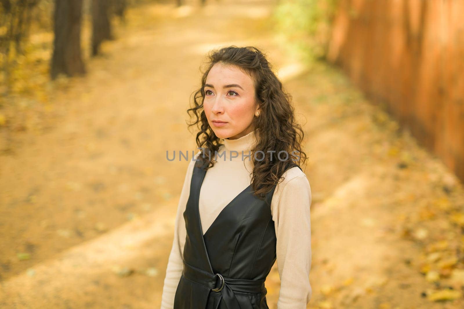Autumn portrait of a beautiful happy curly woman in fall season copy space mockup. Millennial generation female. Natural beauty concept by Satura86