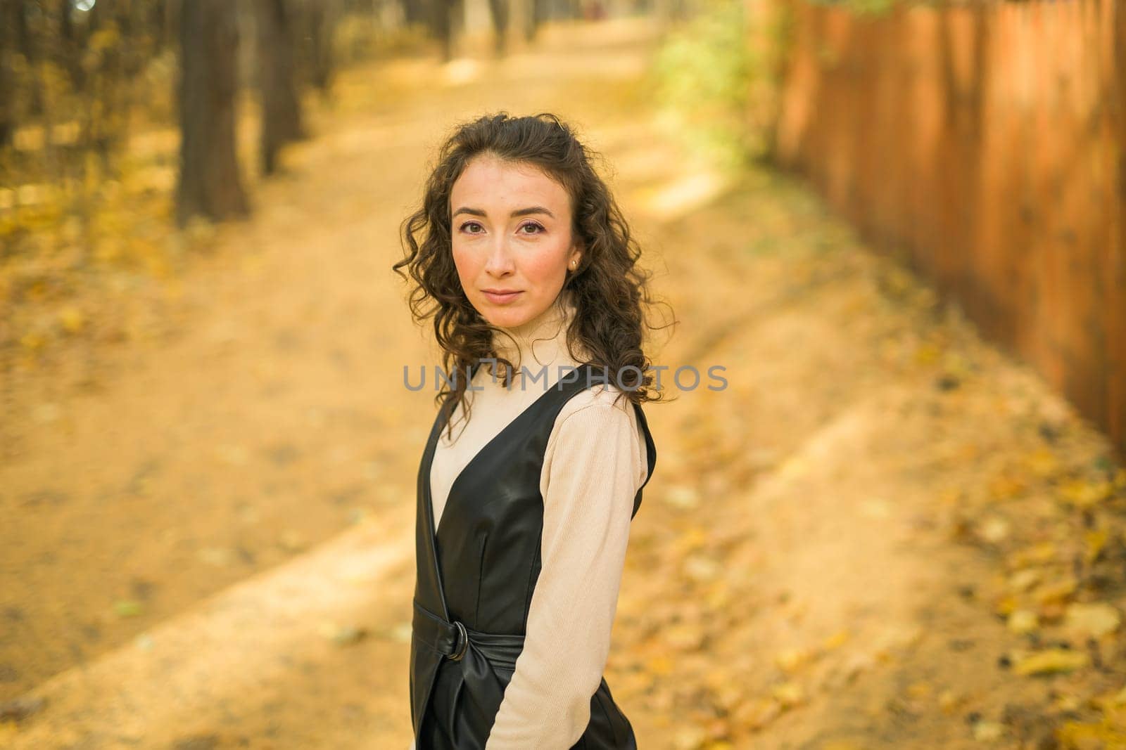 Autumn portrait of a beautiful happy curly woman in fall season copy space mockup. Millennial generation female. Natural beauty concept by Satura86