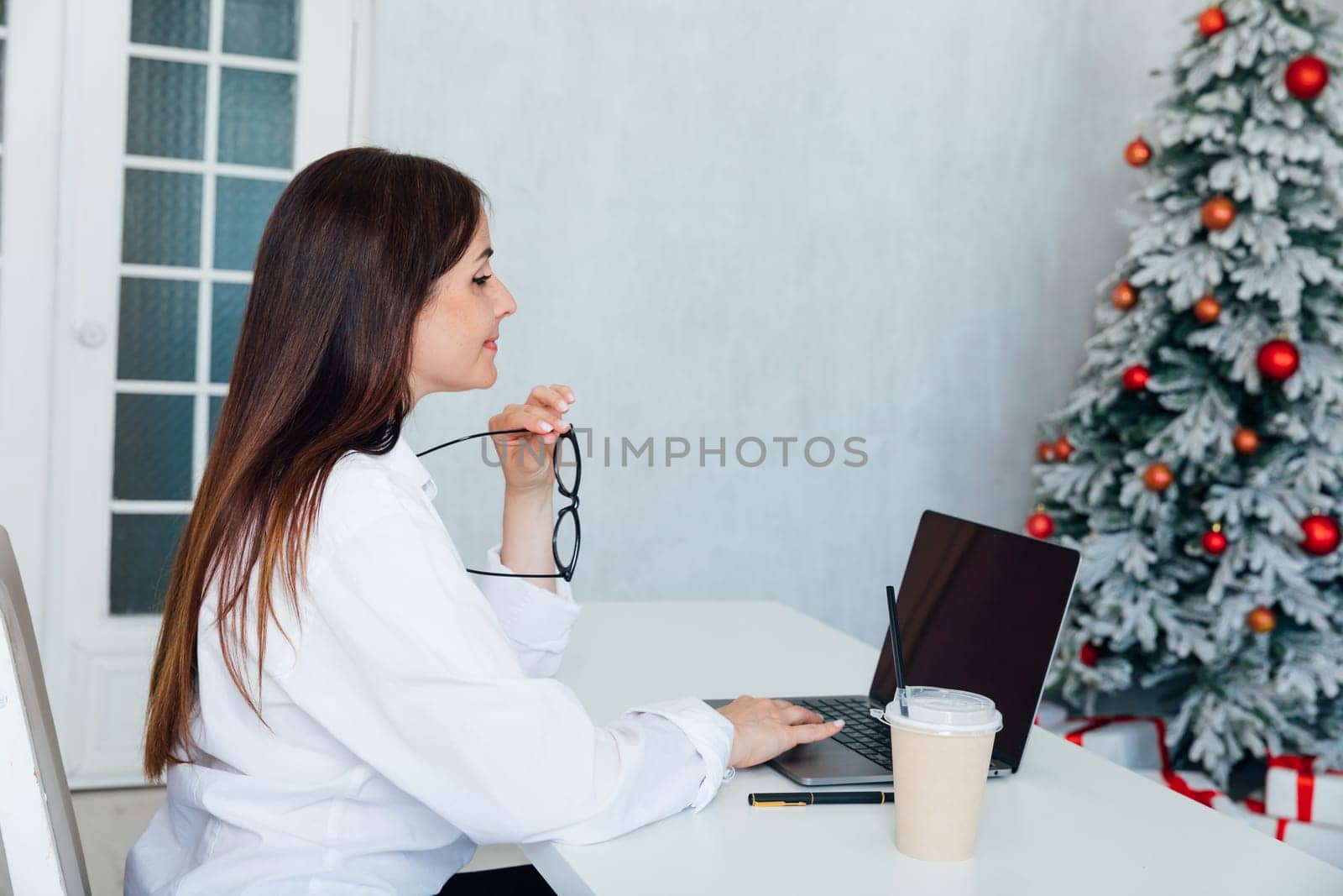 woman working on laptop at christmas tree