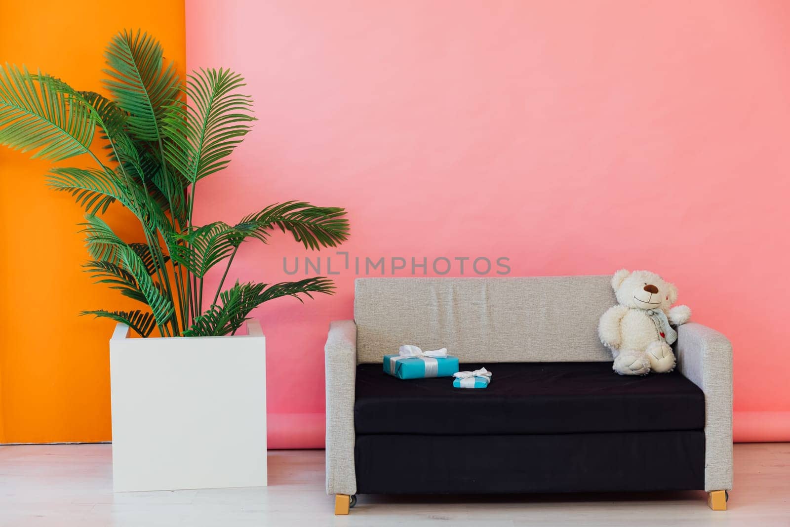 Black and grey sofa in the interior of a multicolored room