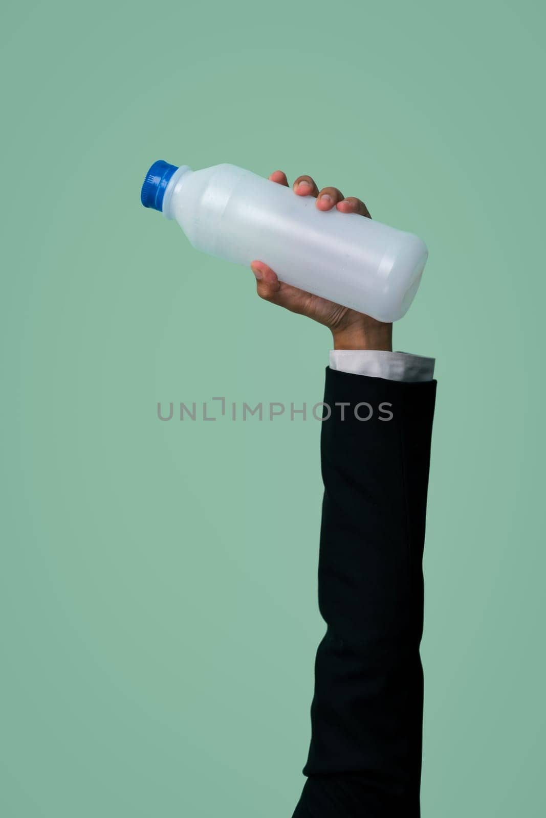 Businessman's hand holding plastic bottle on isolated background. Quaint by biancoblue