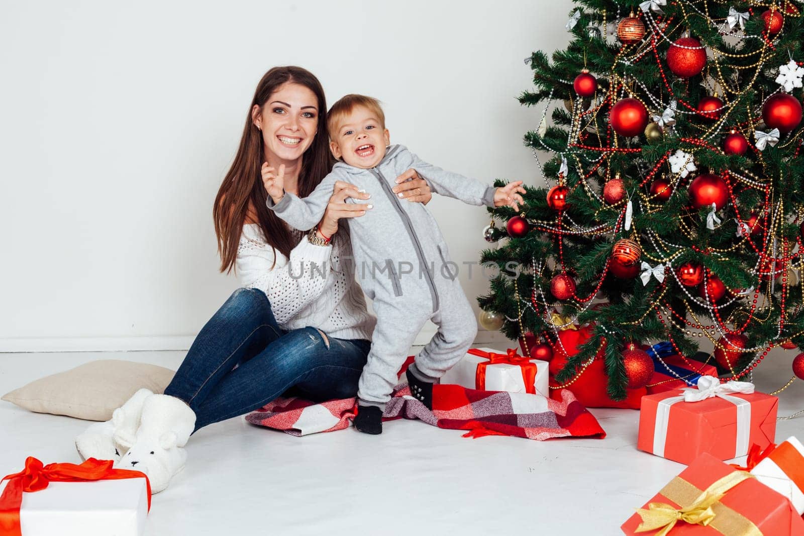 mother and little boy at Christmas tree with gifts