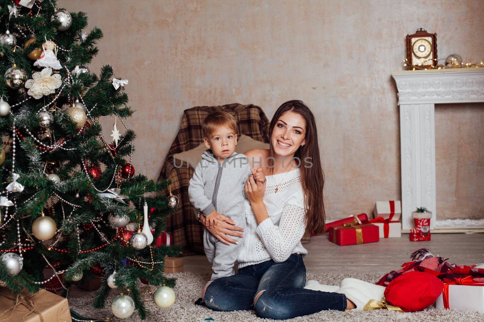 mother and little boy at Christmas tree with gifts