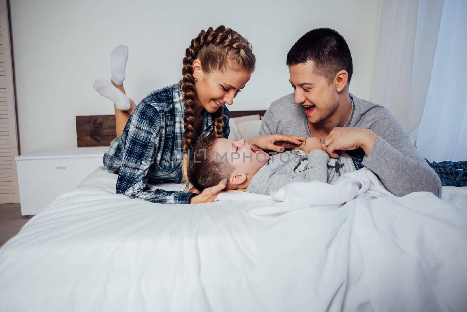 mom and dad and little boy in the bedroom by Simakov