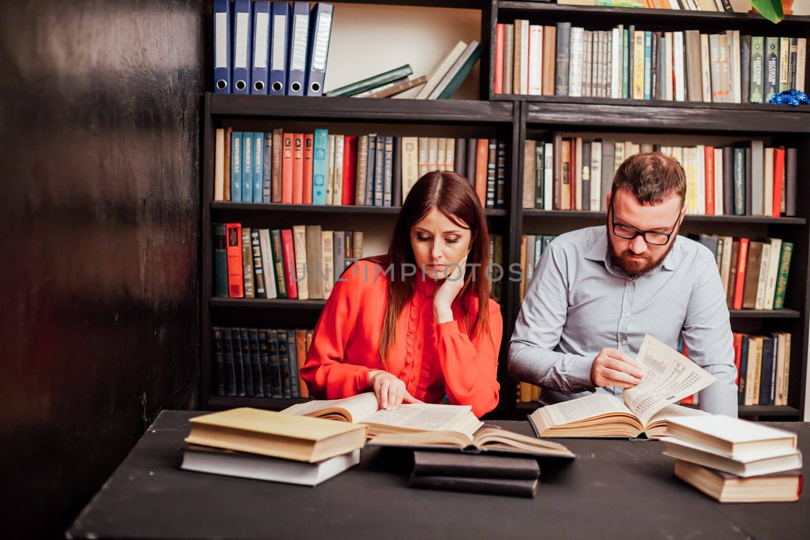 a man and a woman reading a book in the library before the exam 1