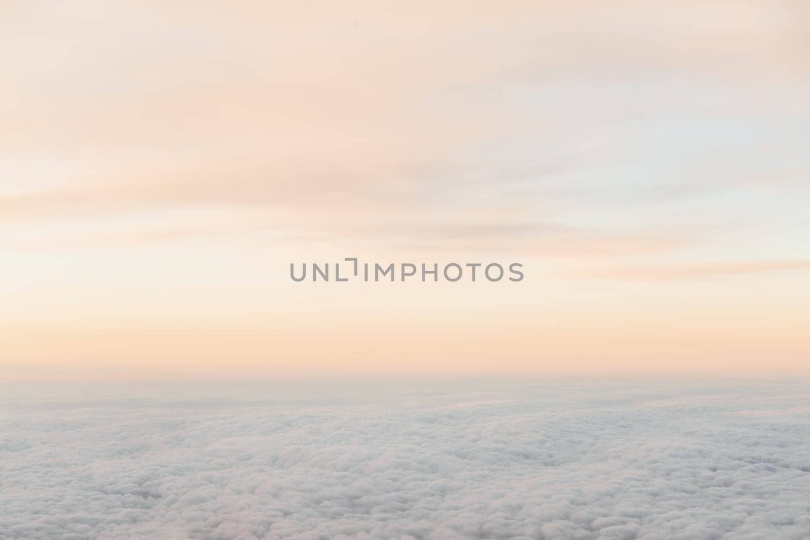 flying above the clouds at sunset landscape from an airplane by Simakov