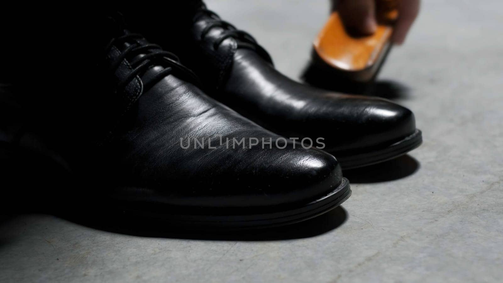 Waxing leather black classic shoes. Stock footage. Close up of cleaning and polishing boots