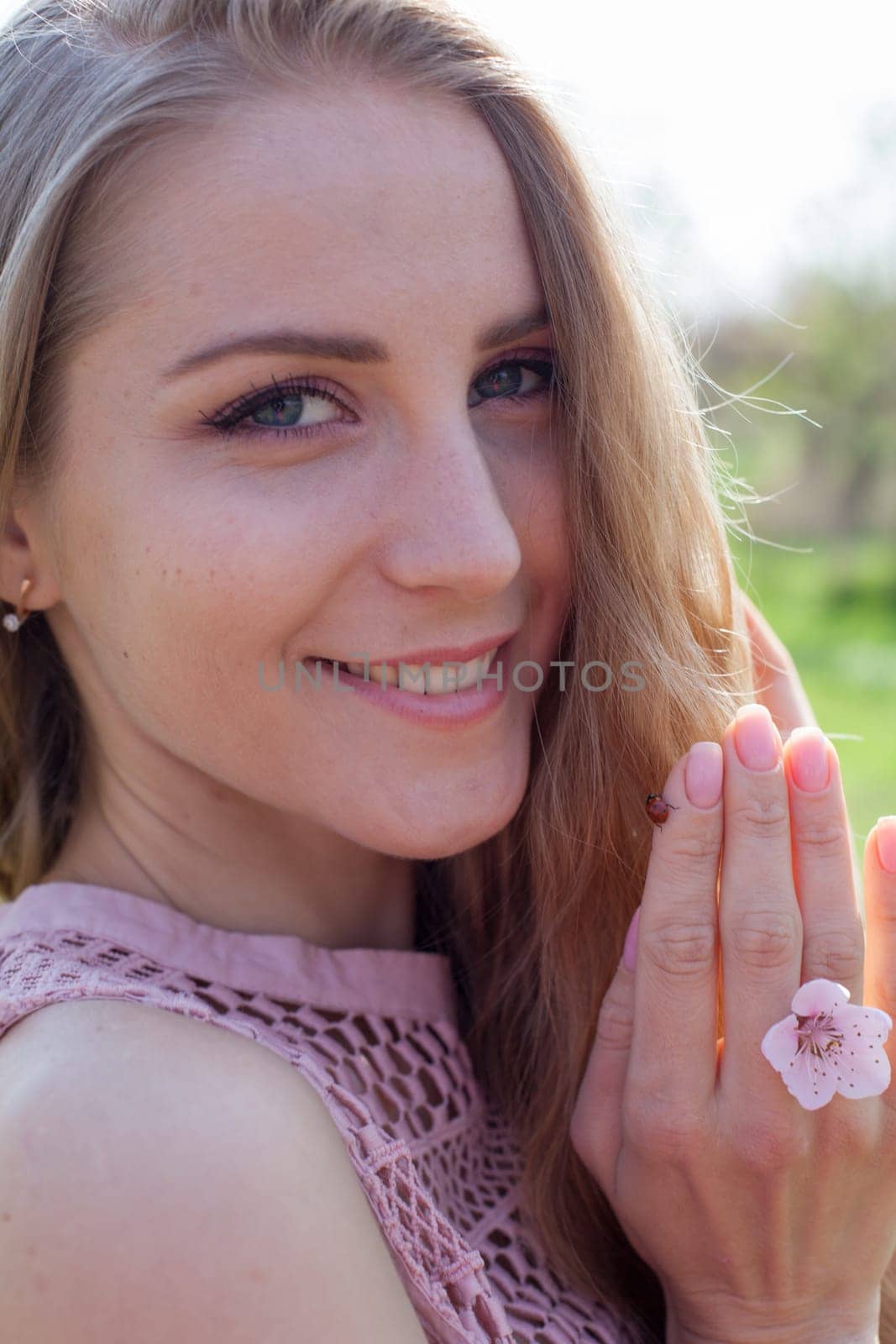 Portrait of a beautiful fashionable blonde woman in a pink dress and a ladybug by Simakov