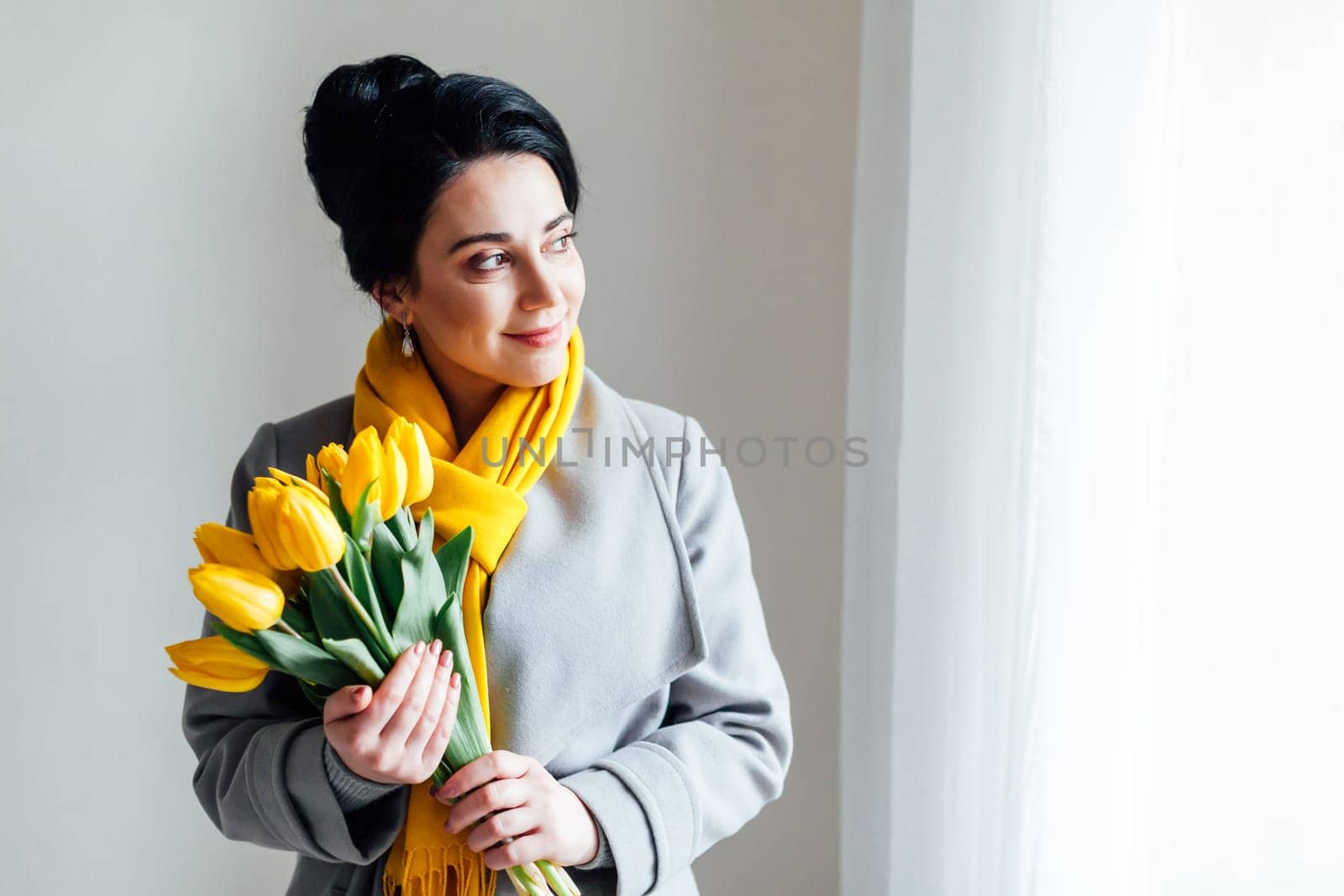 brunette woman in coats with yellow tulips by Simakov