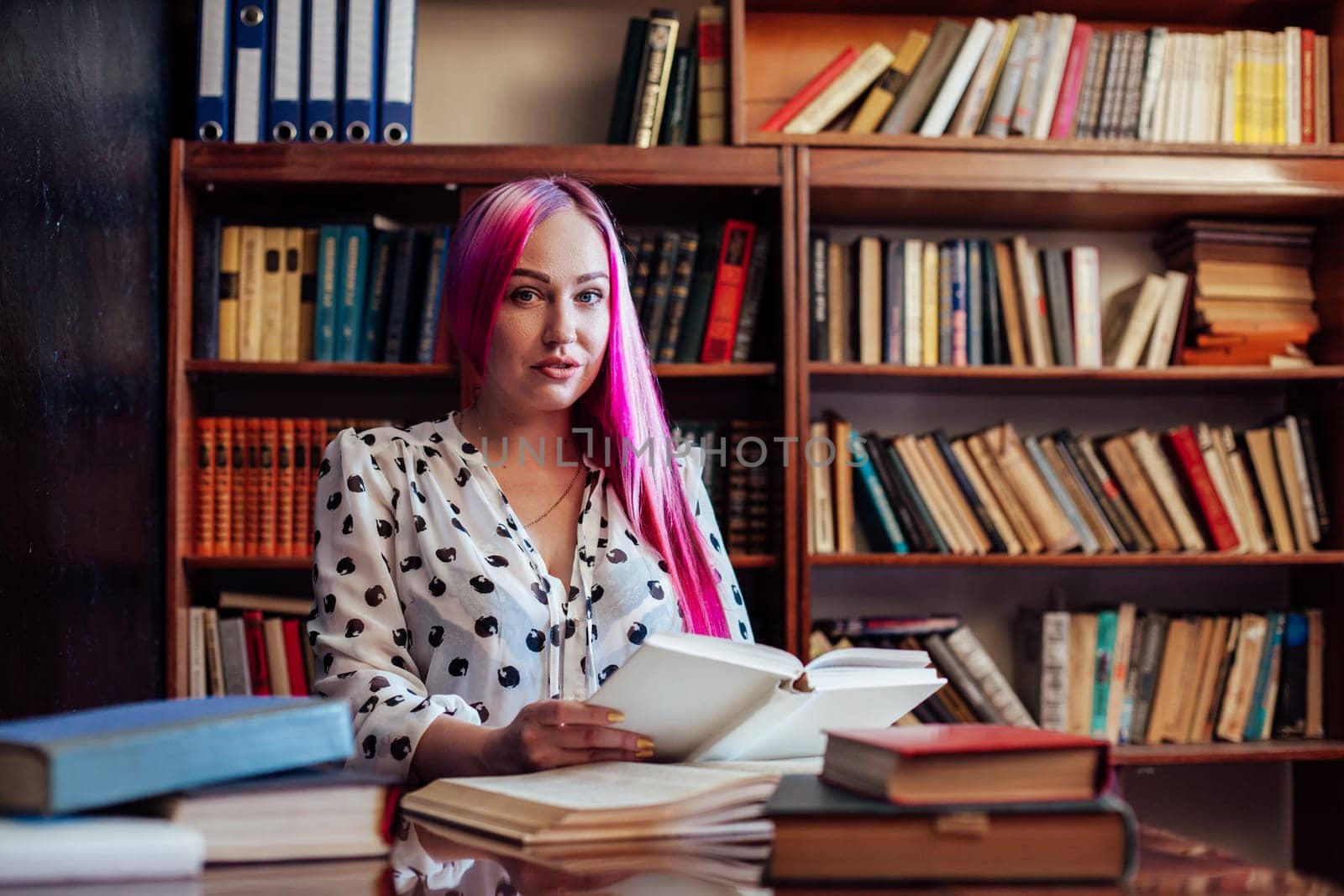 girl is preparing for the exam reads a lot of books in the library 1