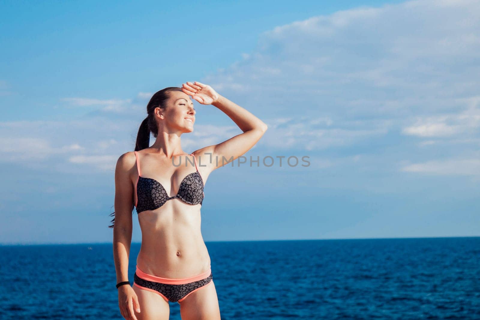 girl in bathing suit sunning on the beach by the sea by Simakov