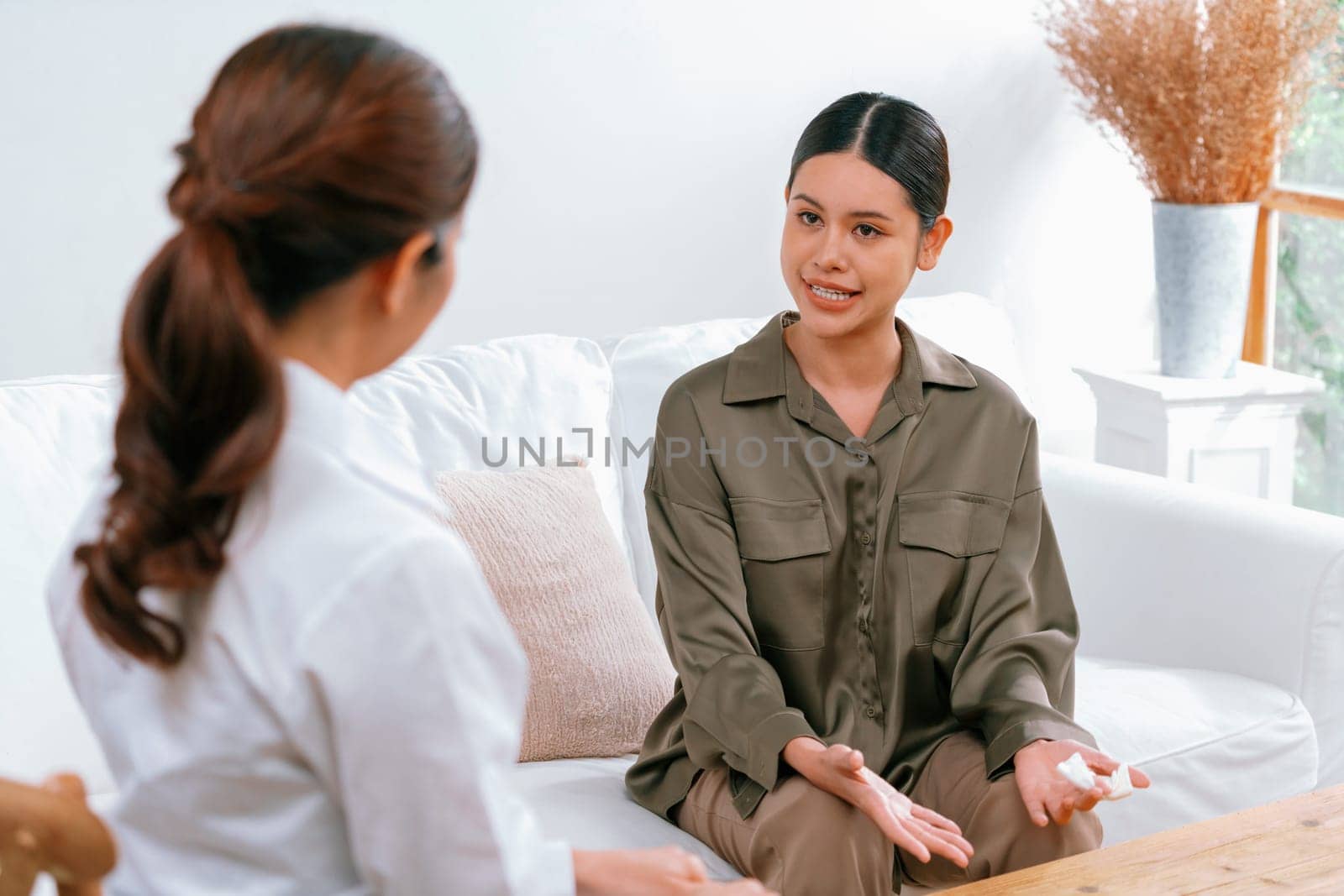 Sad PTSD woman patient in uttermost therapy for mental health with psychologist, depression or grief after life failure. Frustrated trauma young woman talking to a psychologist about emotion in clinic