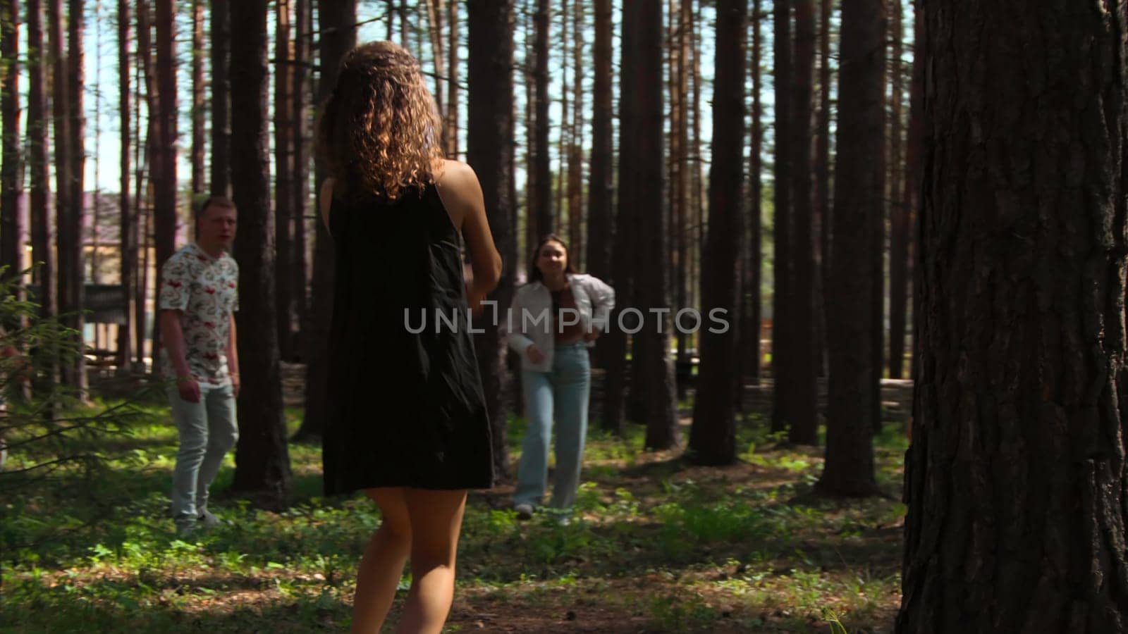 People play volleyball in forest. Stock footage. Tourists at recreation center play volleyball in forest. Vacationing people play ball in forest on sunny summer day.