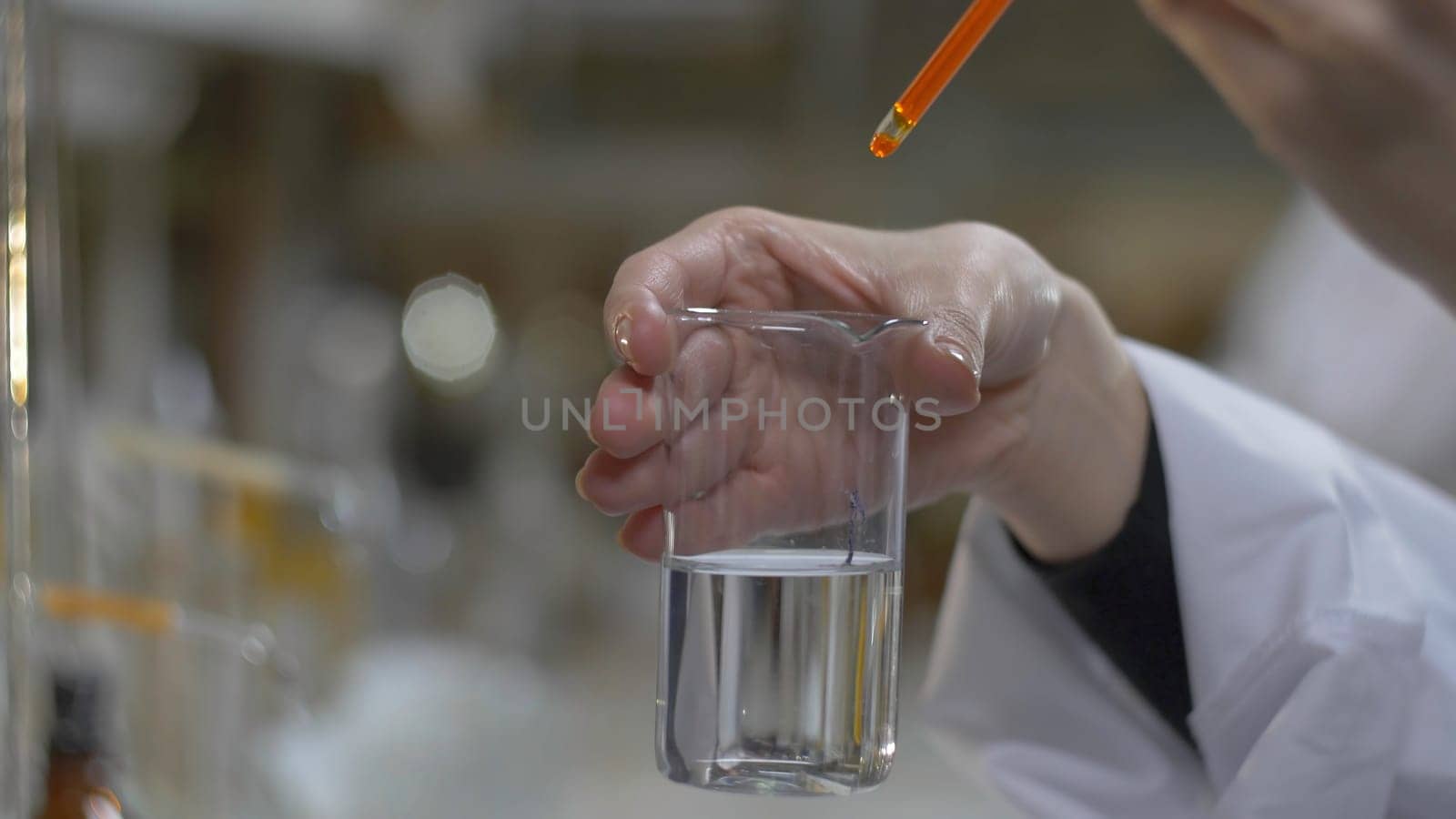 Chemist hands mixed substance of red color in test tubes. Doctor Pours red Chemicals Into In Flask. Close Up f