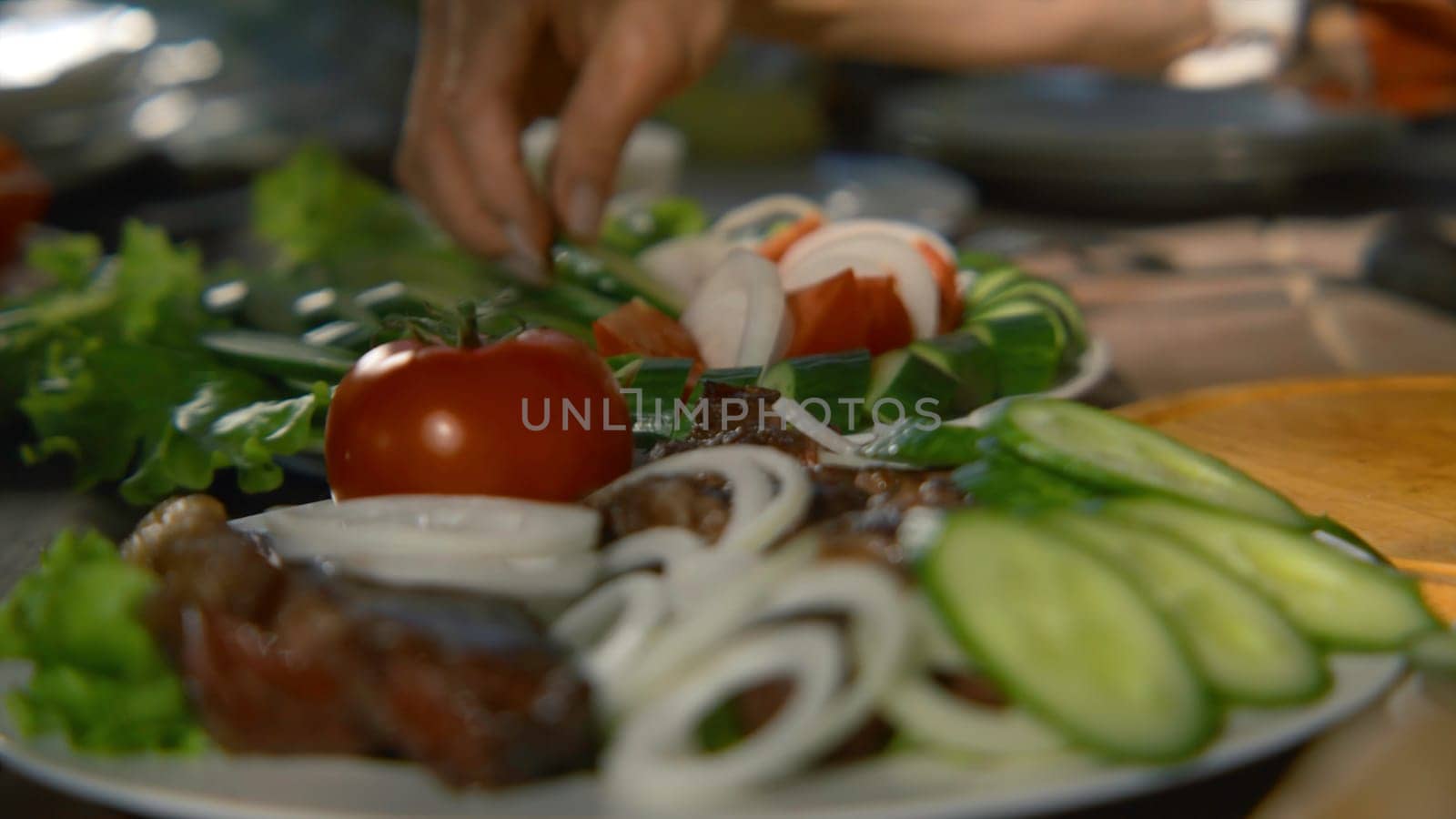 Close-up of people cutting and preparing table in nature. Stock footage. People relax in nature with appetizing table with vegetables. Bright table with vegetables and barbecue in nature.