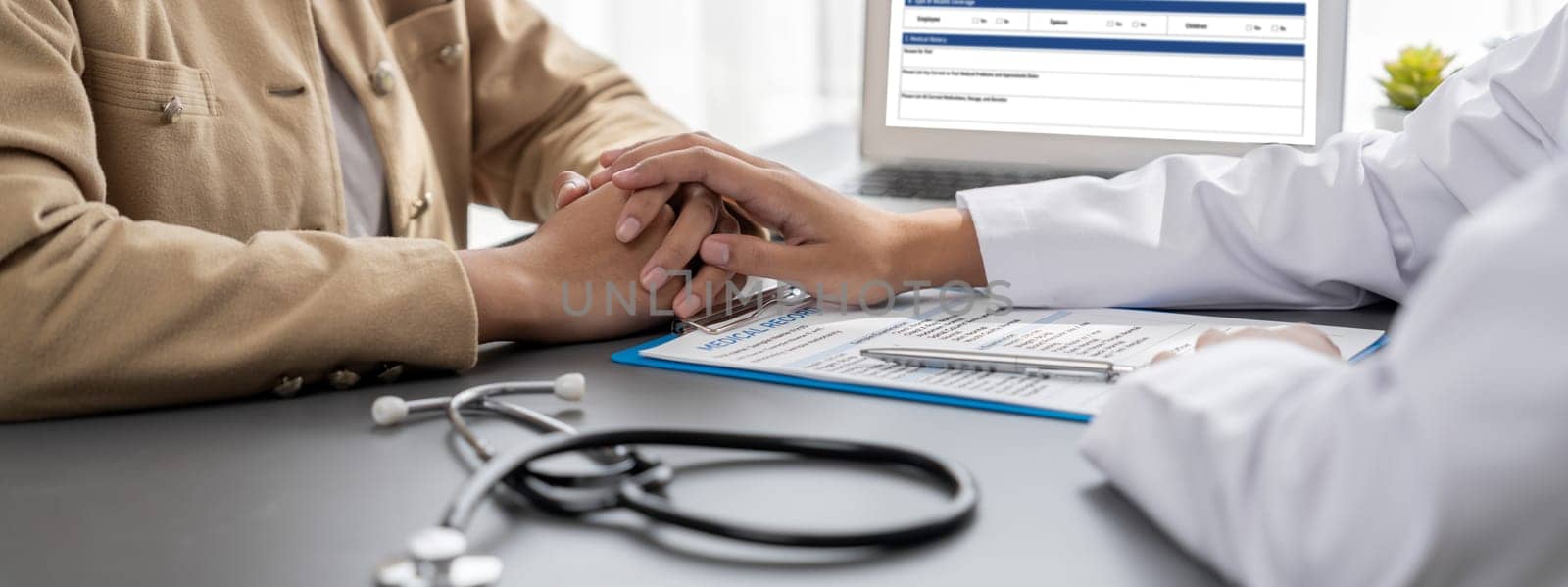 Doctor show medical diagnosis report and providing compassionate healthcare consultation while holding young patient hand for being supportive and professional in doctor clinic office. Neoteric