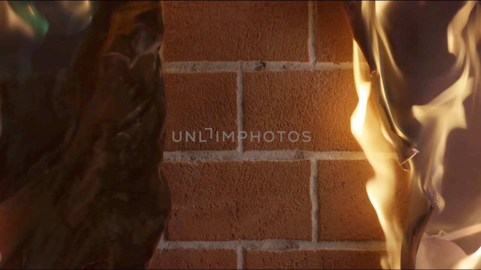 Burning paper. Paper with charred edges on a brick wall f