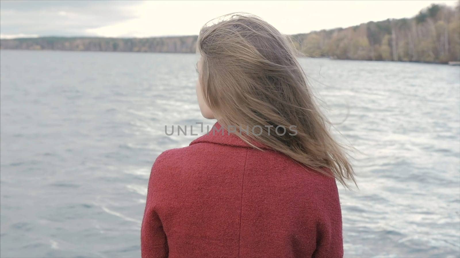 Rear View Of Young Woman Enjoying Lake View. Rear view of alone young adult hipster girl standing on the beach, looking to sea, travel lifestyle p