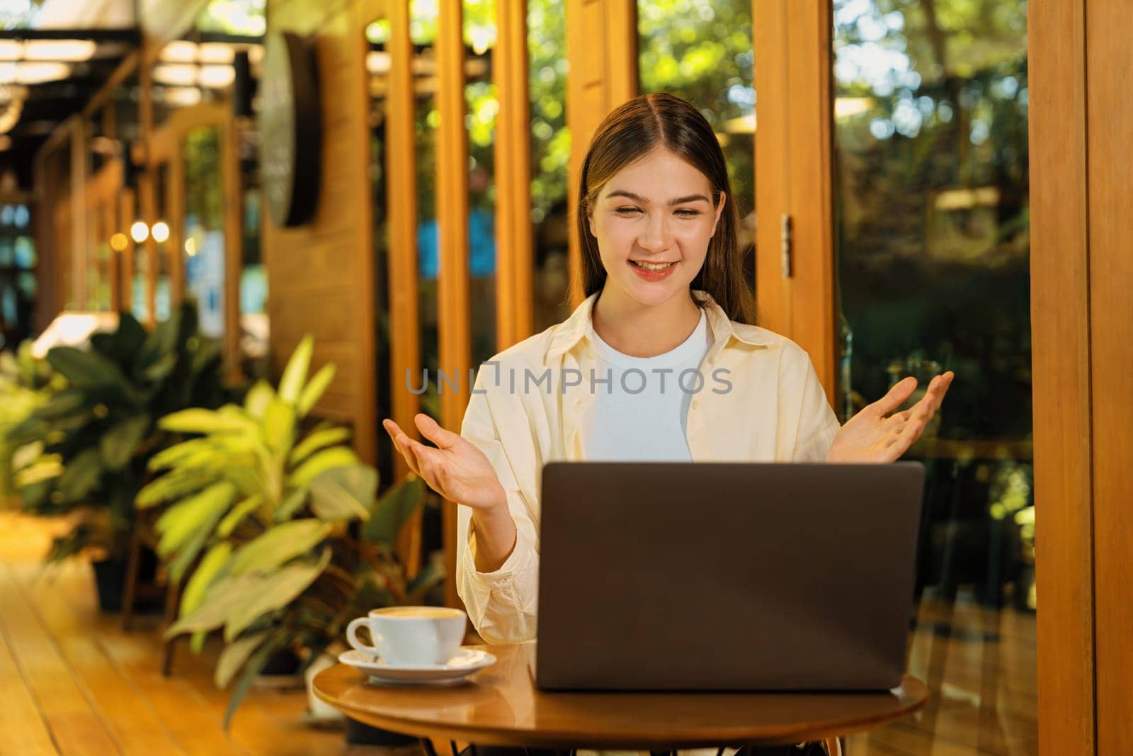 Young woman working on laptop at outdoor cafe garden. Expedient by biancoblue