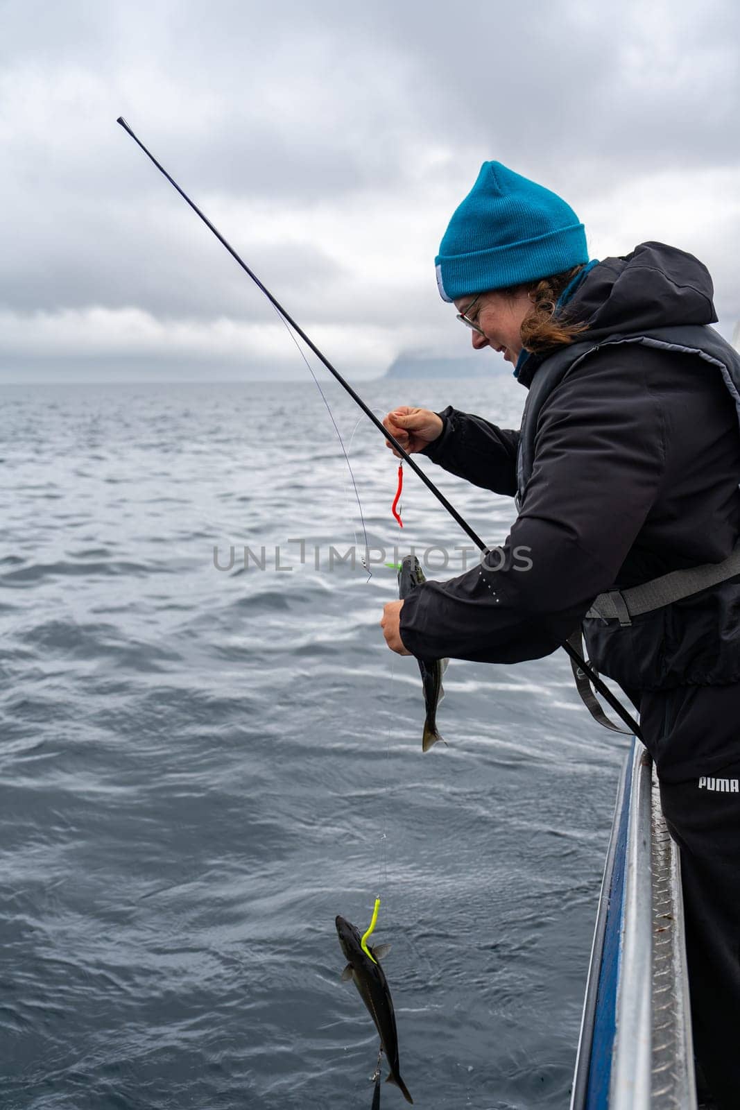 Happy Female Angler Displaying Her Fishing Success in the Norwegian Sea, Favorite Hobby by PhotoTime