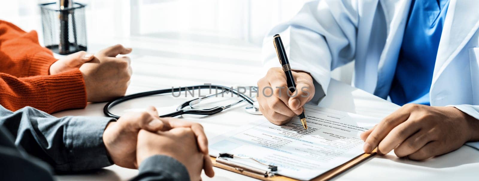 Couple attend fertility consultation with gynecologist at hospital as part family planning care for pregnancy. Loving husband and wife support each other through the doctor appointment. Panorama Rigid