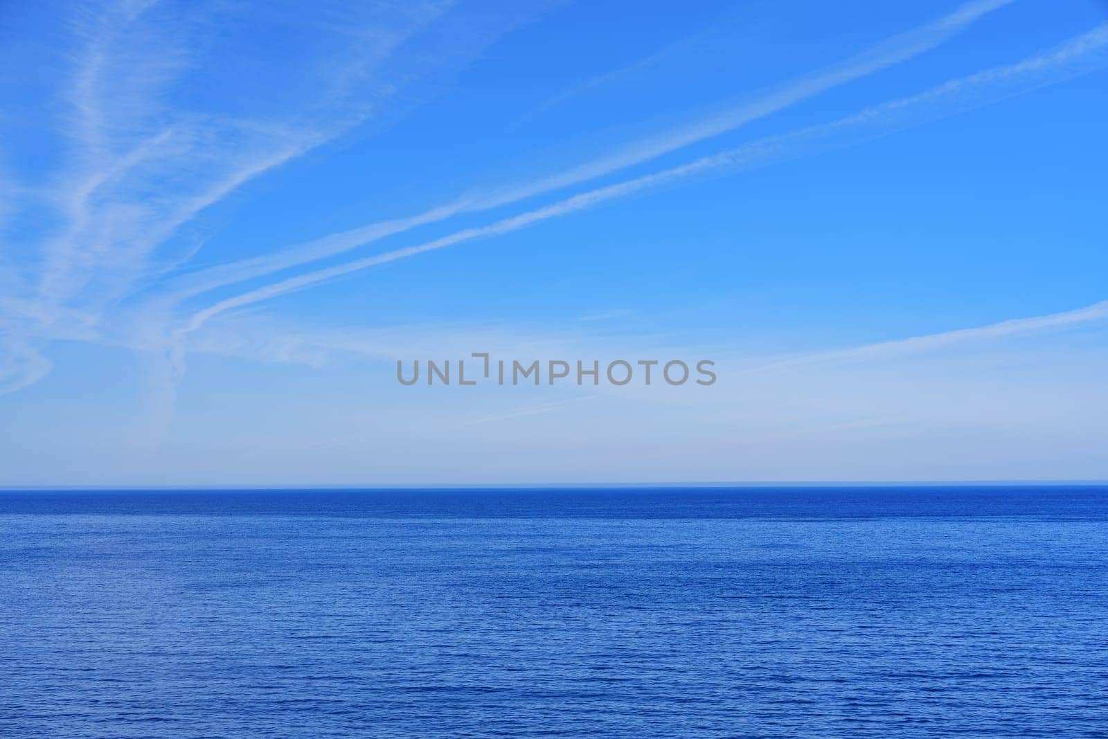 Tranquil seascape with a clear blue sky stretching to the horizon, perfect for promotional advertisements and travel brochures. The serene scene evokes a sense of peace and relaxation.