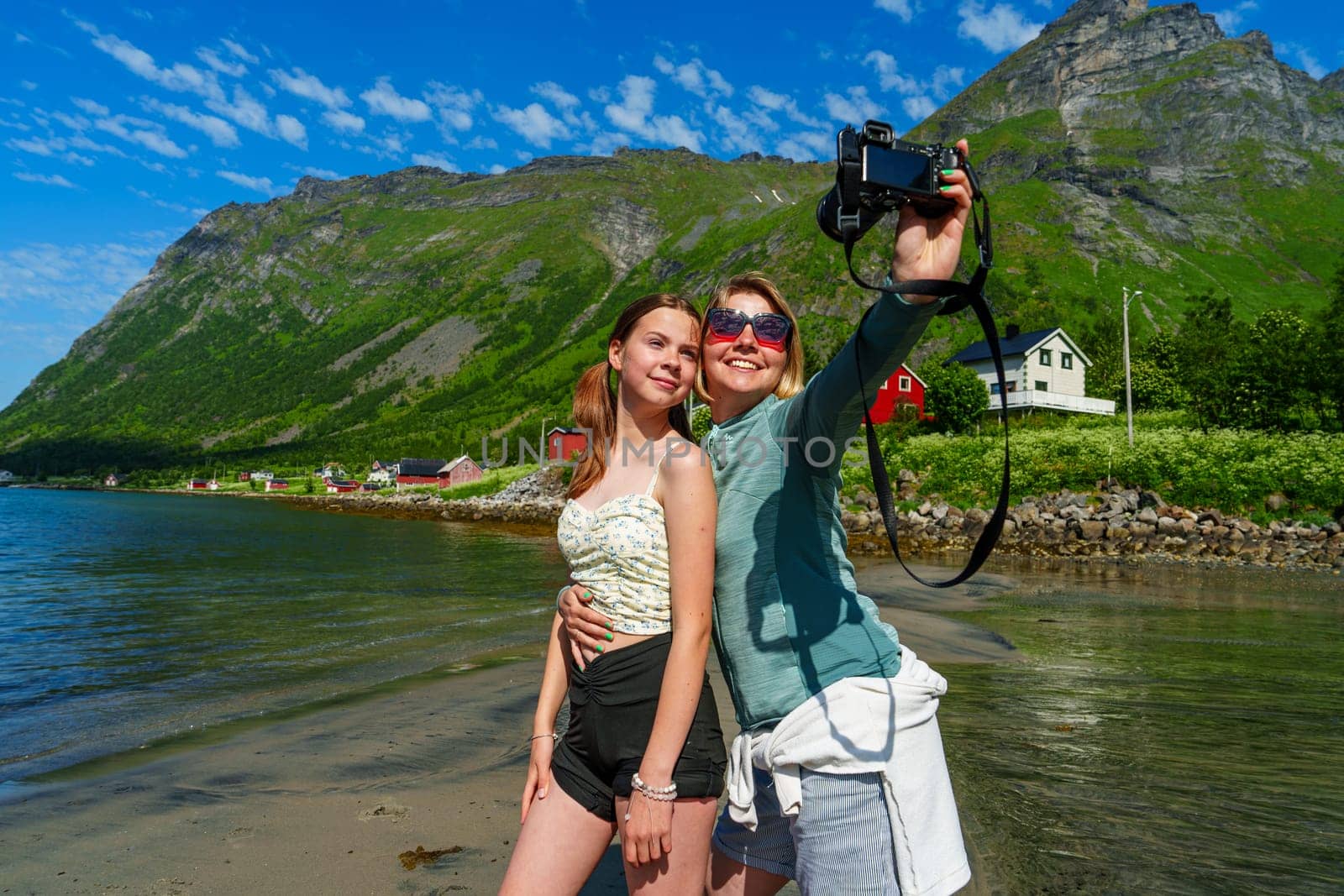 A stylish young woman is seen taking a selfie with a professional camera in an urban setting, showcasing her creativity and passion for photography while enjoying a modern lifestyle.