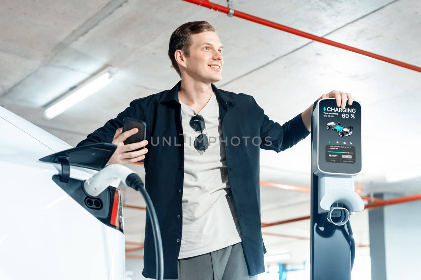 Young man travel with EV electric car to shopping center parking lot innards by biancoblue