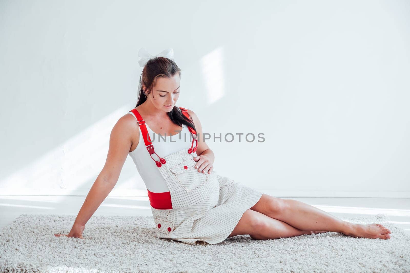 a pregnant woman sitting on the floor razovarivaet with a baby in the belly