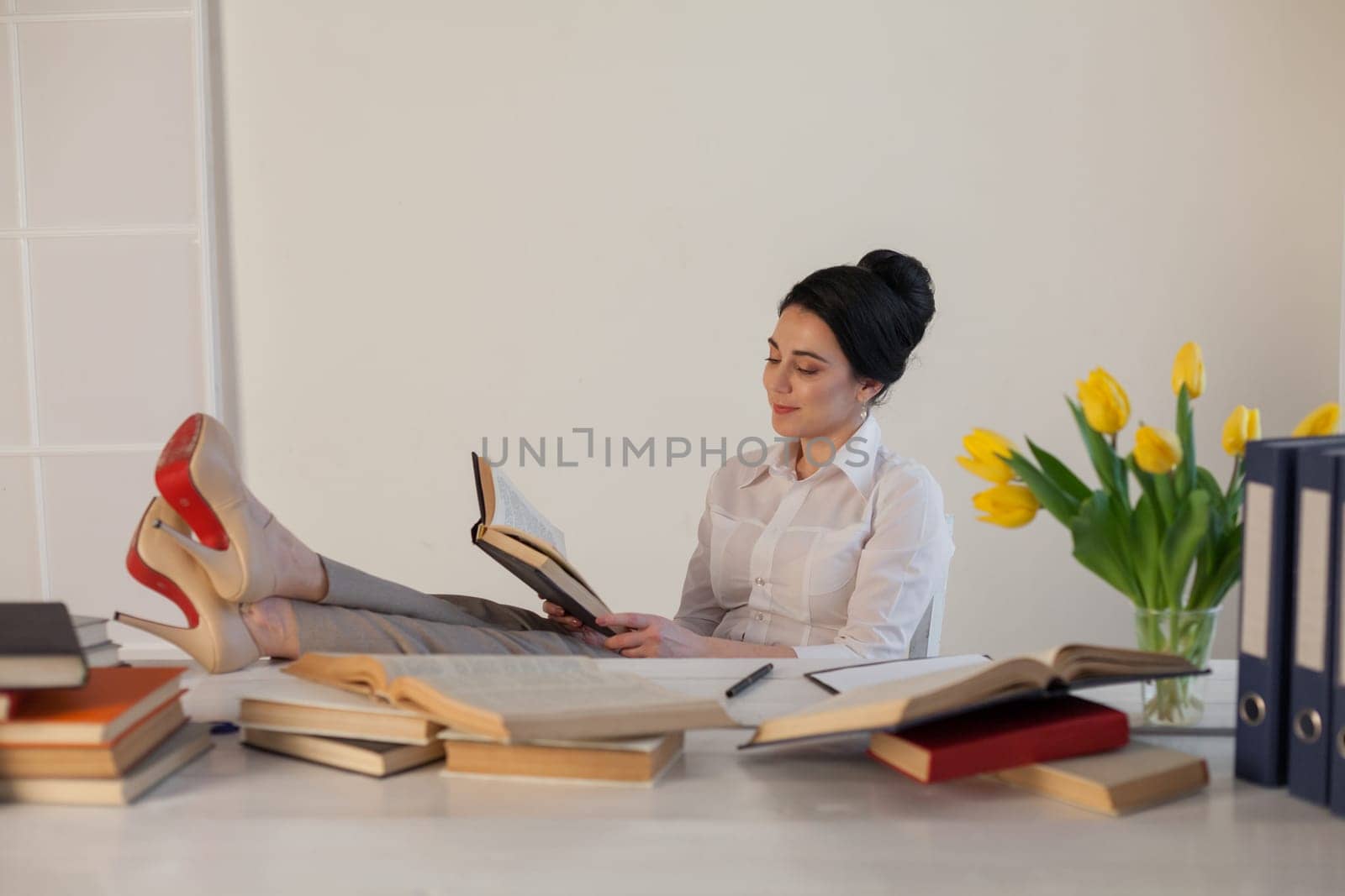 a woman in a business suit reads books in the Office 1