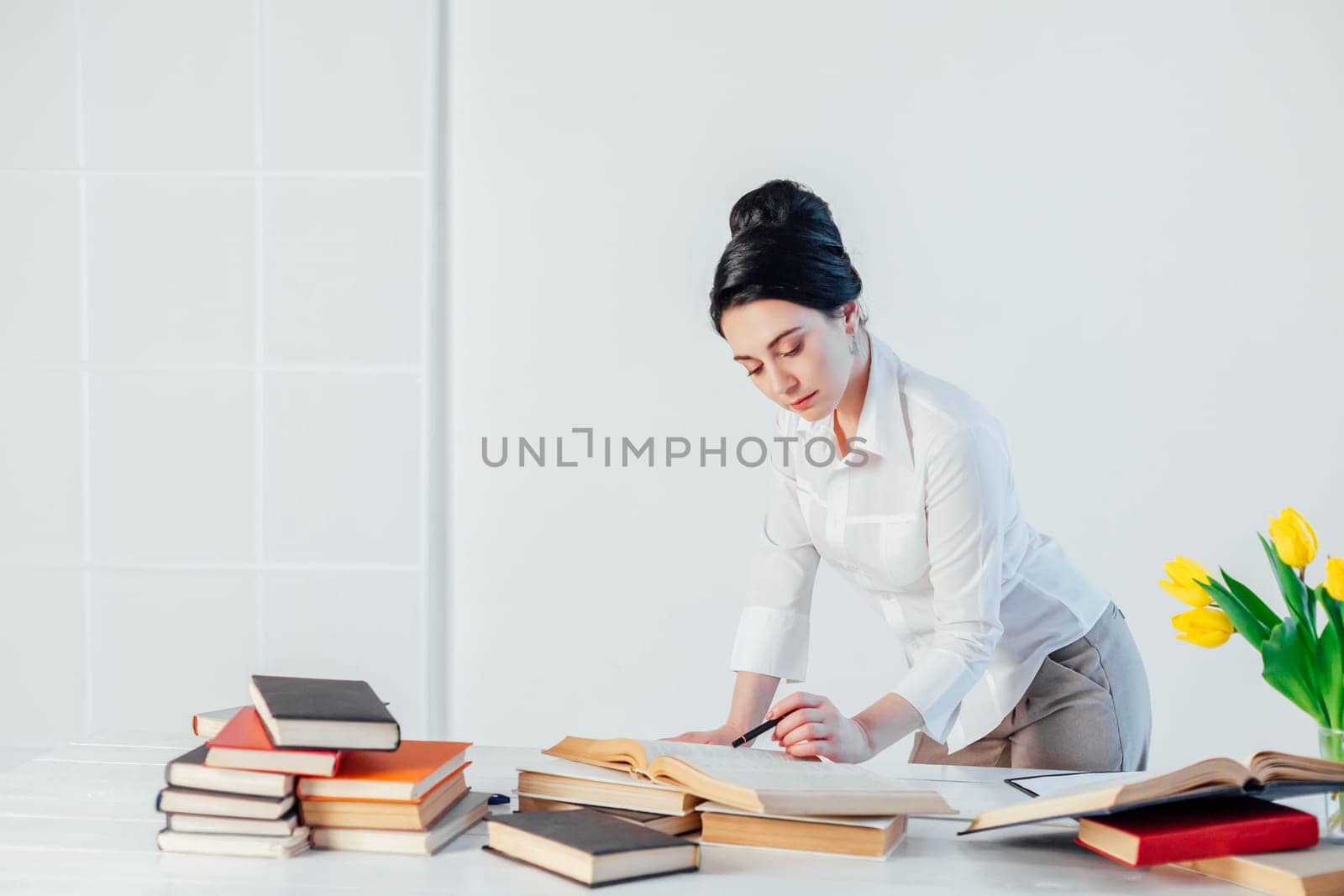 beautiful girl reads books at the table preparing for the exam 1