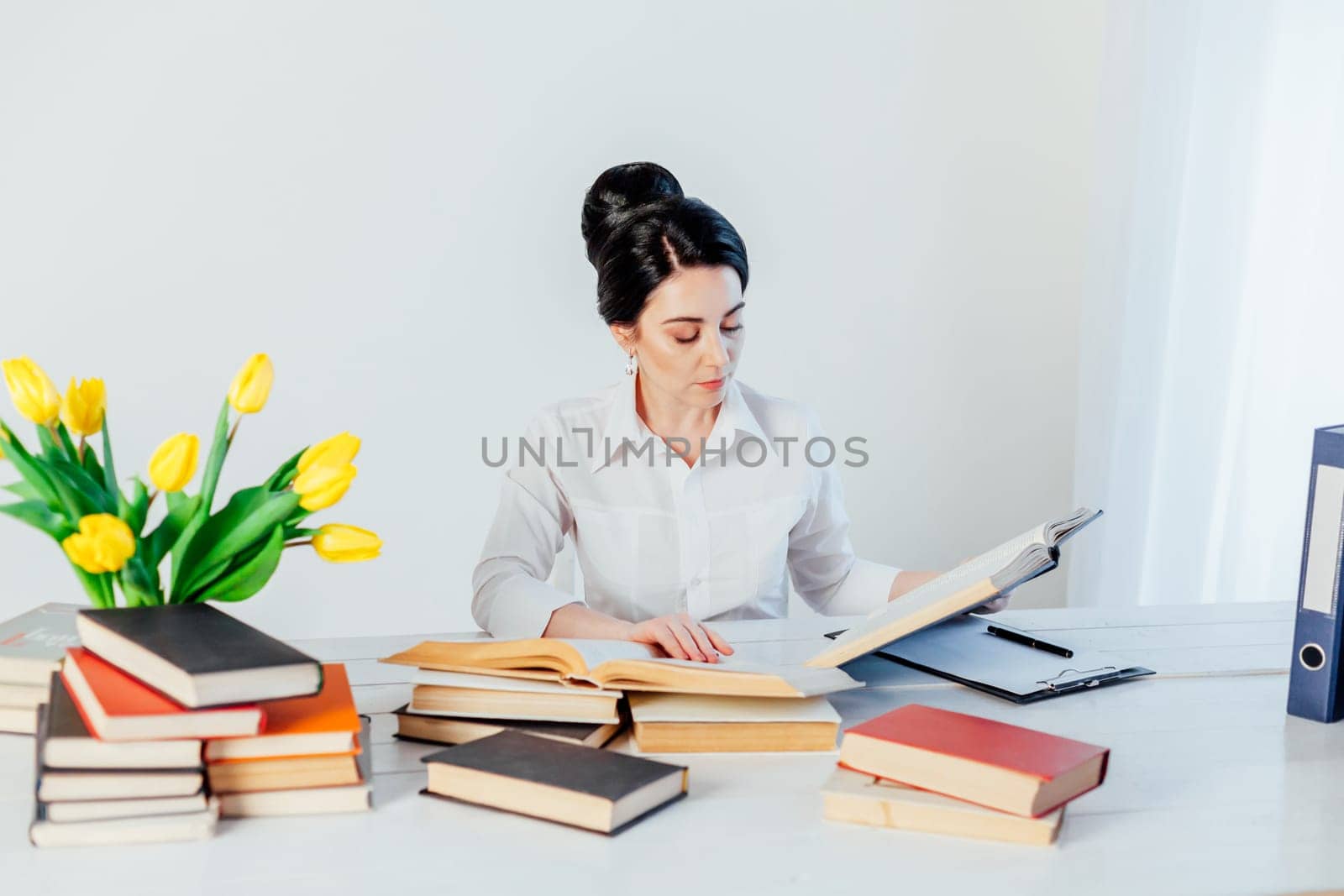 teacher business Lady reads books in the Office by Simakov