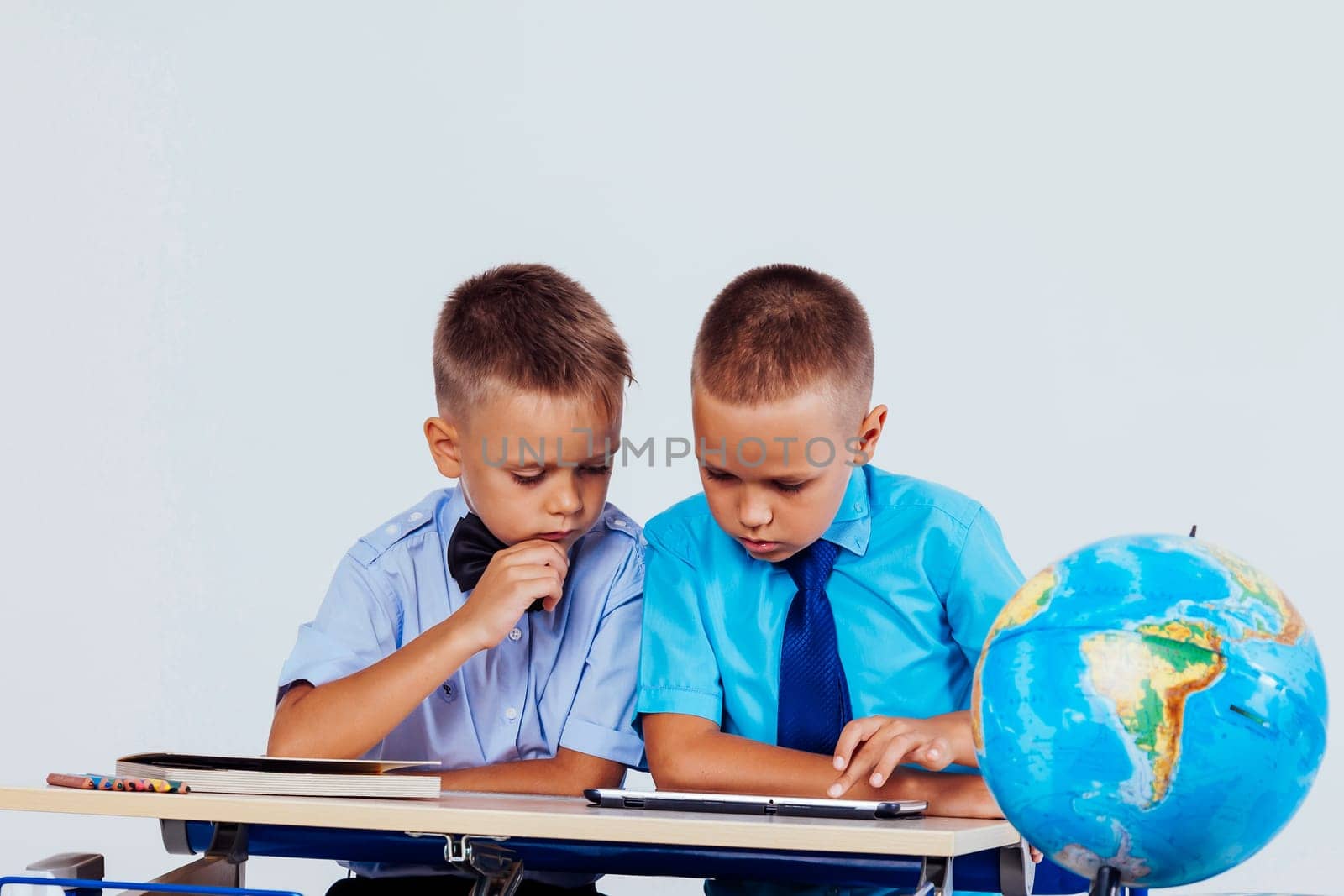 the two boys are looking at Internet Tablet school 1
