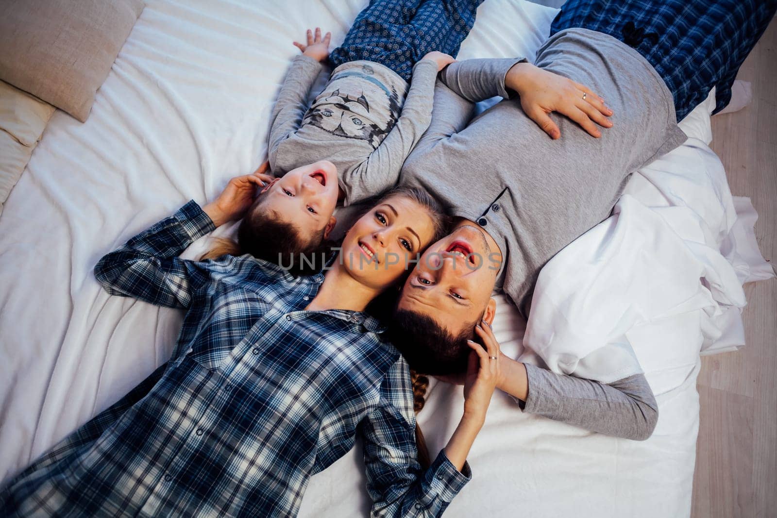mom dad son in the morning in bed by Simakov