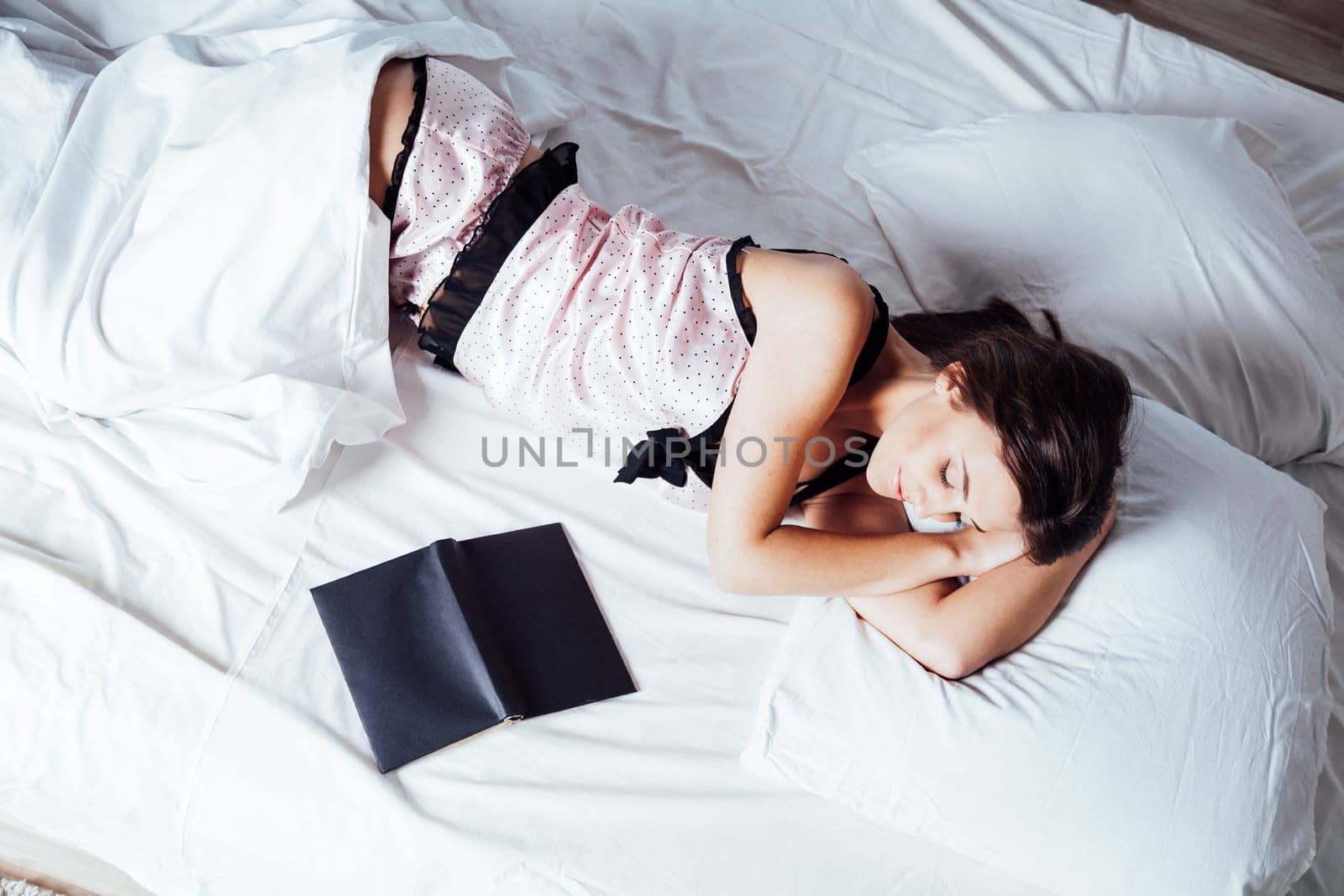 girl in pajamas lying on the bed with a book before bed 1