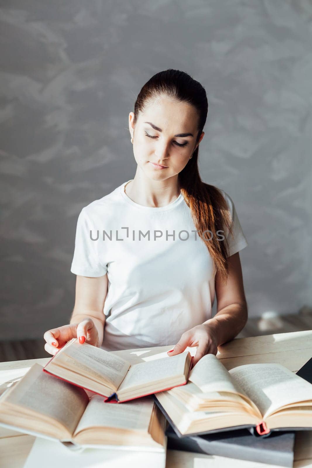 girl reading a book and drinking coffee works at the computer