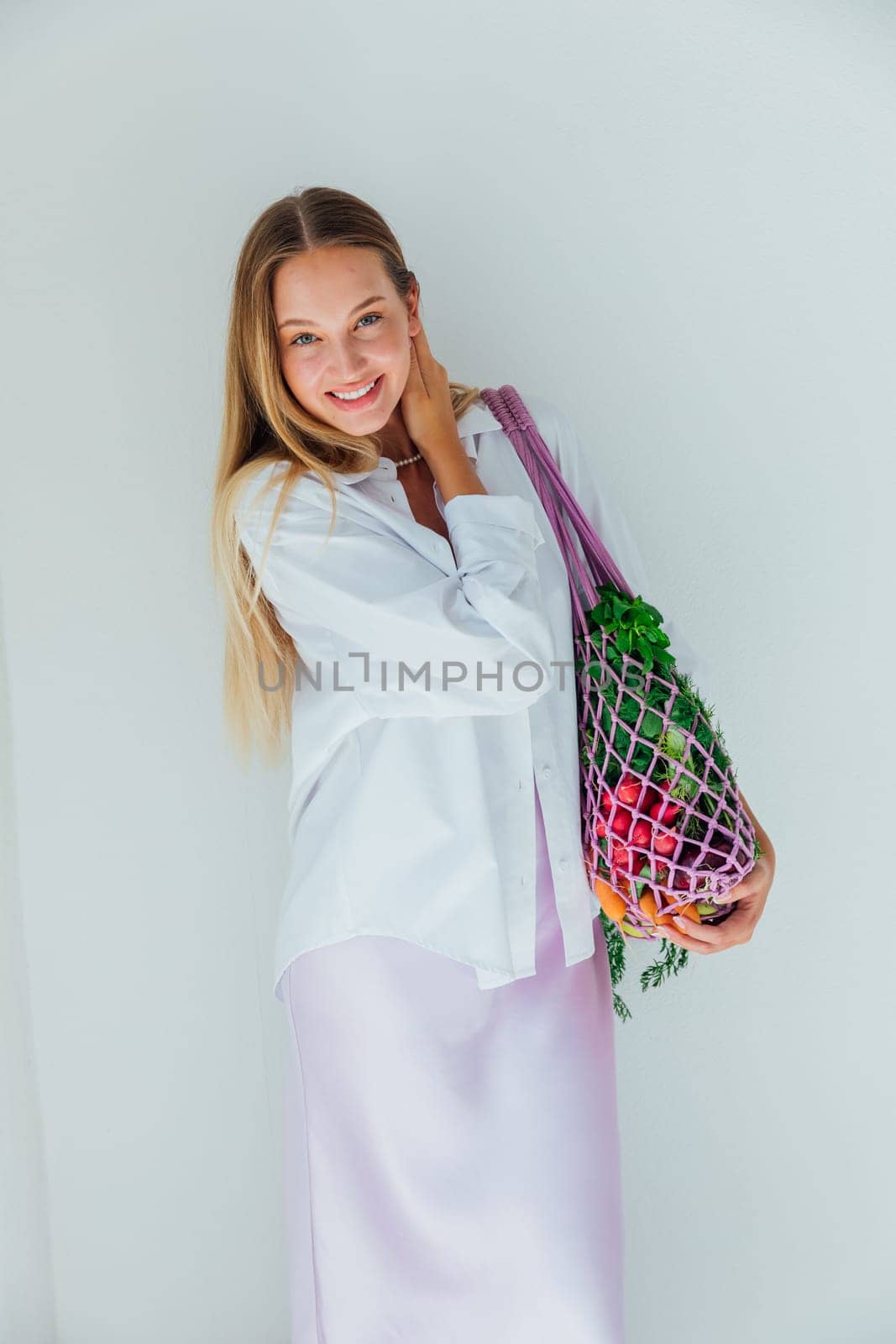 Female nutritionist holding bag with vegetables for cooking by Simakov