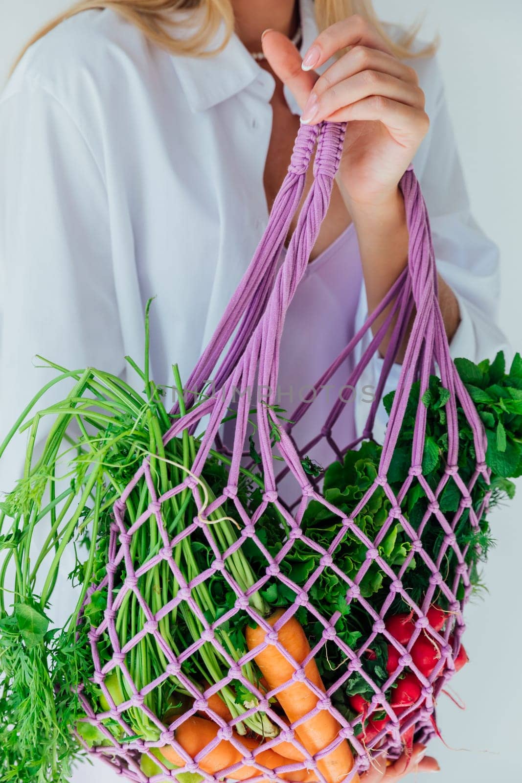 Female nutritionist holding bag with vegetables for cooking by Simakov