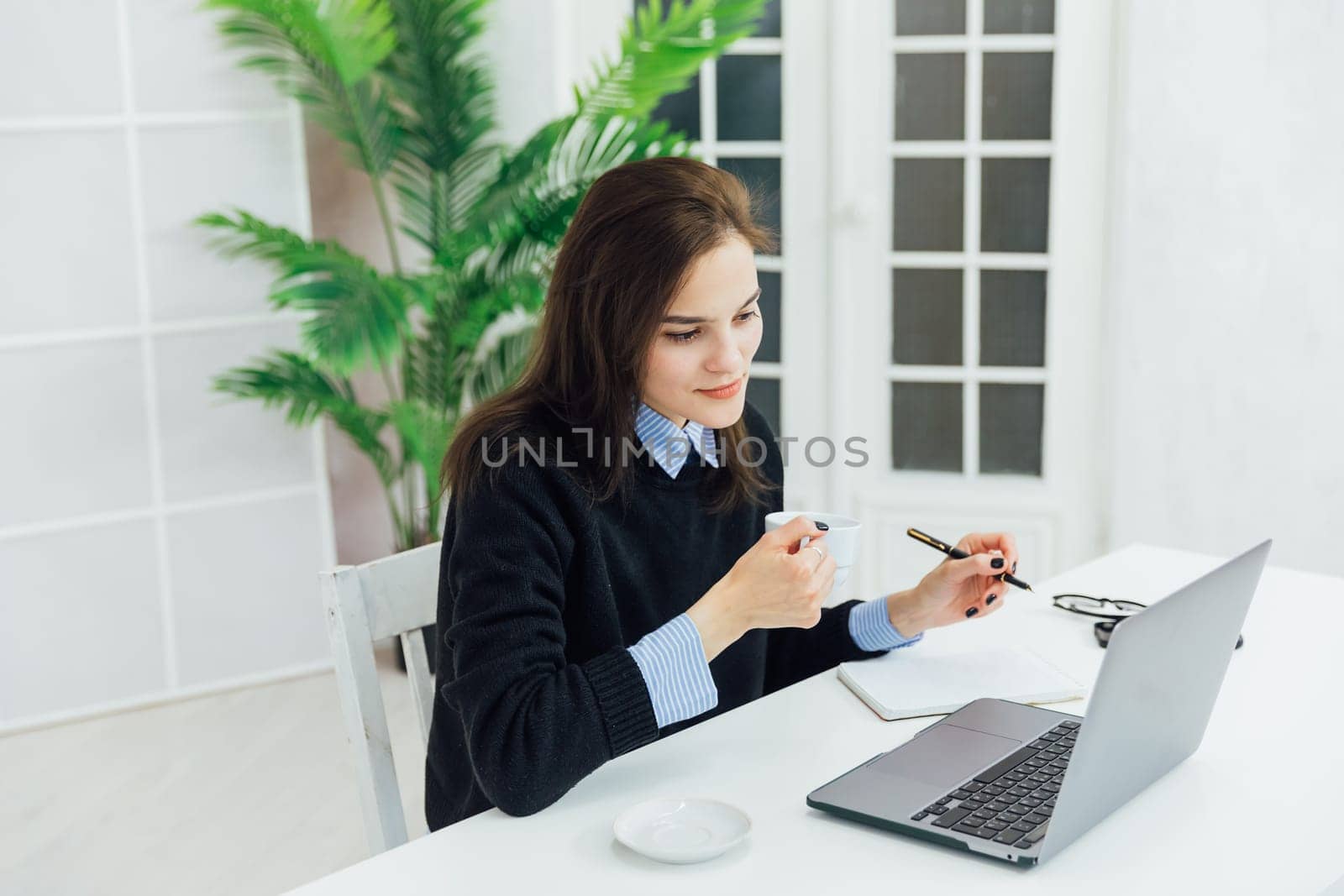 Woman working on laptop online financial business from office by Simakov